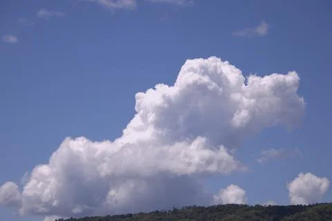 A large cloud in the sky with a blue sky behind it Stock Photos