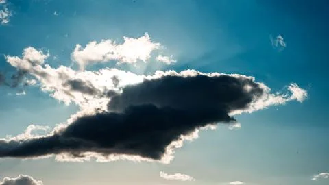 A large cloud in the sky with a sun shining through it Stock Photos