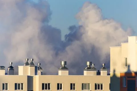 A large cloud of smoke over the roofs of apartment buildings Stock Photos