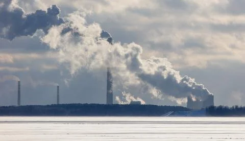 A large cloud of smoke is rising from a power plant 스톡 사진