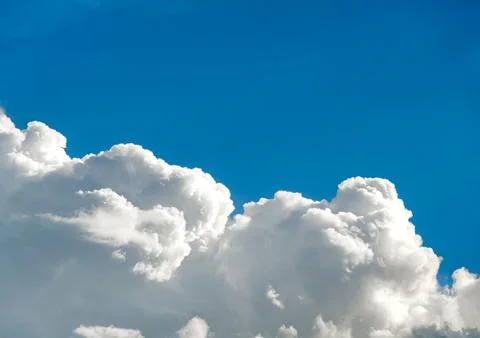 A large cloud, taking up half of the photo, in the blue sky. Stock Photos