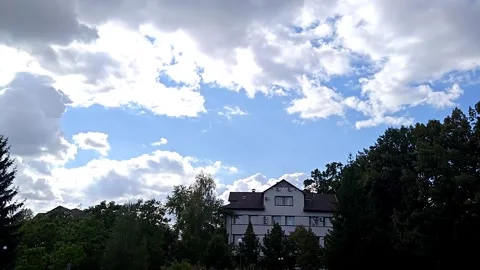 Large clouds float over a building (time-lapse video) Stock Footage 317578755