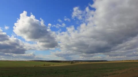 Large clouds flying on blue sky over autumn harvest field Stock Footage 12249235