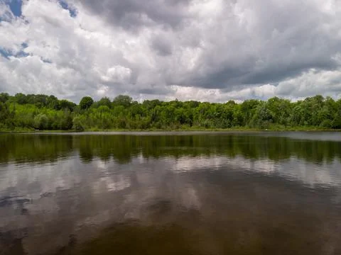 Large clouds over a small lake Stock Photos