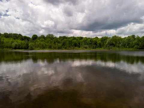 Large clouds over a small lake Stock Photos