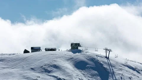 Large Clouds Rushing Behind Ski Lift On Snow Covered Peak Video stock 137848374