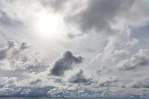 Large clouds with the sun at its zenith in the sky during the day Foto stock