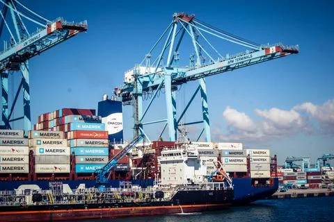 Large CMA CGM container ship unloading cargo under gantry cranes at port of.. Stock Photos