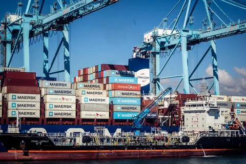 Large CMA CGM container ship unloading cargo under gantry cranes at port of.. Stock Photos