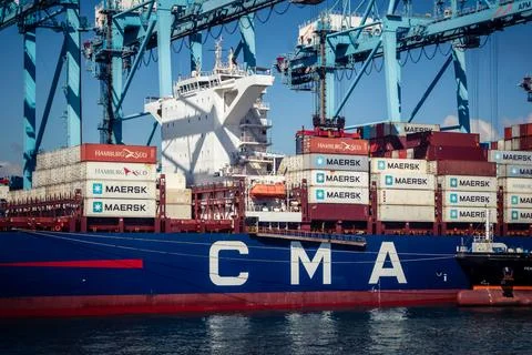 Large CMA CGM container ship unloading cargo under gantry cranes at port of.. Stock Photos