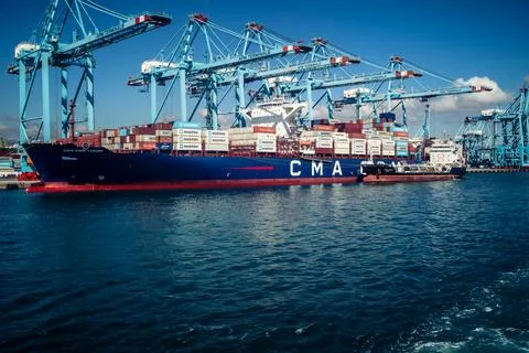 Large CMA CGM container ship unloading cargo under gantry cranes at port of.. Stock Photos