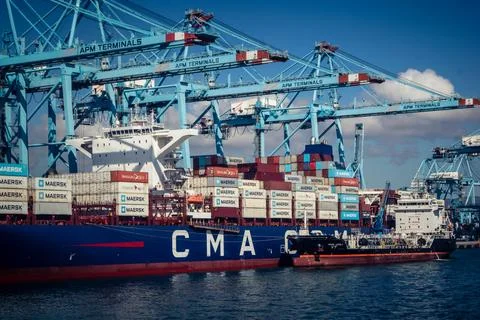 Large CMA CGM container ship unloading cargo under gantry cranes at port of.. Stock Photos