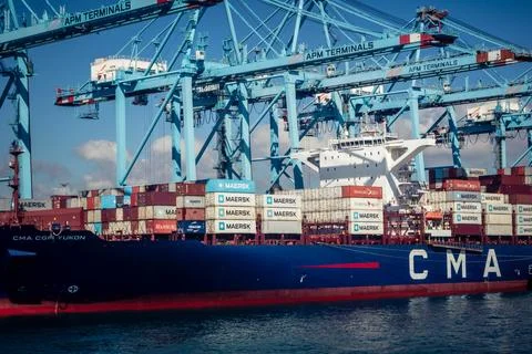 Large CMA CGM container ship unloading cargo under gantry cranes at port of.. Stock Photos