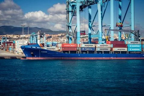 Large CMA CGM container ship unloading cargo under gantry cranes at port of.. Stock Photos