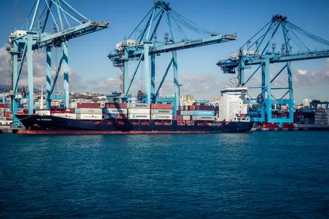 Large CMA CGM container ship unloading cargo under gantry cranes at port of.. Stock Photos