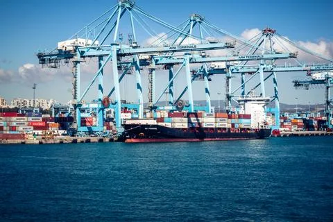 Large CMA CGM container ship unloading cargo under gantry cranes at port of.. 스톡 사진
