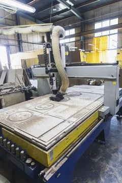 Large cnc machine cuts blanks of various shapes on a plywood sheet Stock Photos