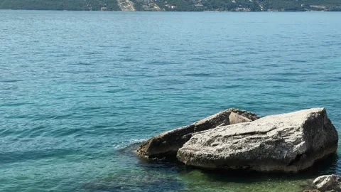 Large coastal rocks sit in clear turquoise water of Kotor Bay Montenegro with Stock Footage 344904210