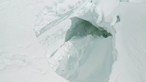 Large collapsed cave in deep thick eternal snow, avalanche danger at mountains Stock Footage 126363814