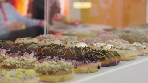 Large collection of donuts displayed on the counter under the glass. Stock Footage 304316965