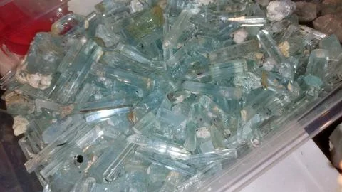 Large Collection Of Raw Light Blue Aquamarine Crystals In Container 库存照片