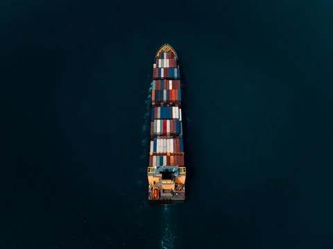 Large Colorful Container Vessel Navigating Deep Blue Ocean Waters Near Si R.. Stock Photos