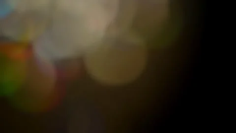 Large coloured bokeh balls create abstract pattern - black background. 4K tripod Stock Footage 260181735