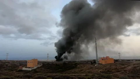 Large column of black smoke coming from a big fire in a car depot in Tenerife 4k Stock Footage 168718604