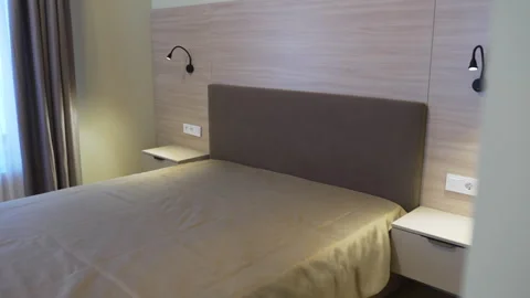 Large comfortable bed with nightstands and glowing lamps Stock Footage 319995089