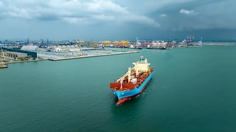 Large Commercial Container Ship Navigating Industrial Harbor Waters In Laem.. Stock-Fotos