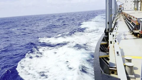 Large Commercial Ship Navigating Through Deep Blue Ocean Creating White Foam Stock Footage 331225189