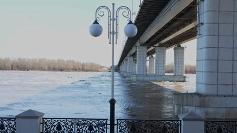 Large concrete bridge pillars over muddy river with floating ice Stock Footage 332432065
