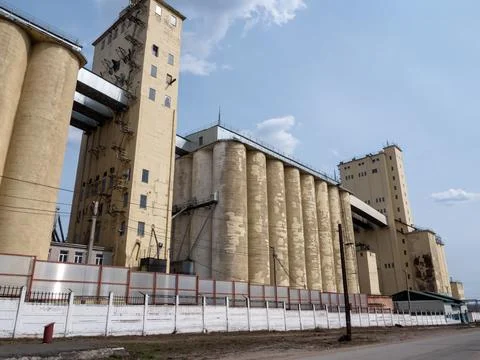 Large concrete grain elevator building against a clear blue sky, industrial.. Stock Photos