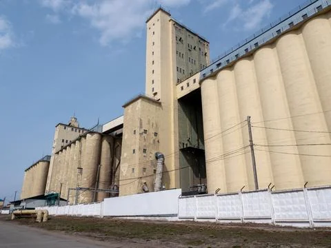 Large concrete grain elevator building against a clear blue sky, industrial.. Stock Photos