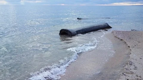 A large concrete pipe lying in the sea on the shore. Stock Footage 122095336