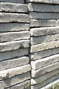 Large concrete slabs stacked in a stack against a bright sun Stock Photos