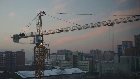 A large construction crane is collected in all rows at dusk, time lapse Stock Footage 71883453
