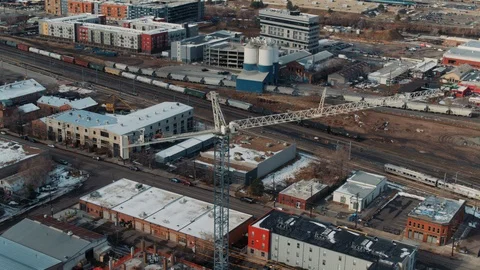 Large construction crane with commuter rail train passing Stock Footage 123093026