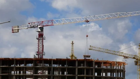 A large construction crane turns, delivers cargo and building materials near Stock Footage 77561603