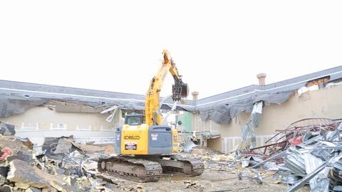 Large construction equipment throws metal scraps at demoliton site A Stock Footage 125056778