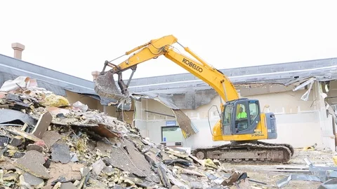 Large construction equipment throws metal scraps at demoliton site D Stock Footage 125056817