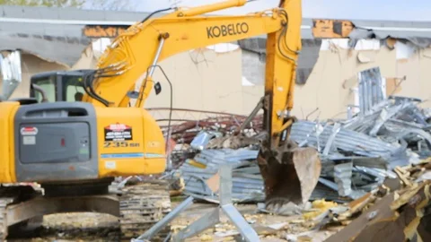 Large construction equipment throws metal scraps at demoliton site C Stock Footage 125056839