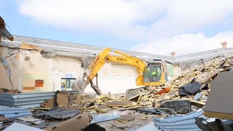 Large construction equipment throws metal scraps at demoliton site E Stock Footage 125056844