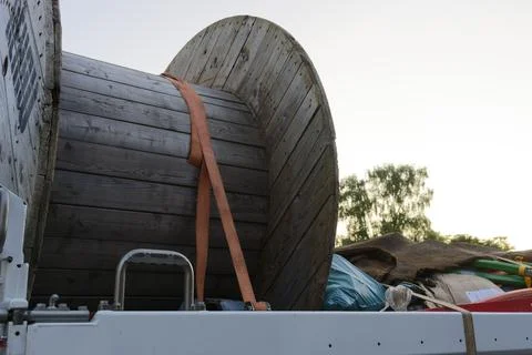 Large construction hose reel on trailer secured with orange strap Stock Photos