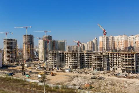Large construction site including several cranes working on a building complex Stock Photos