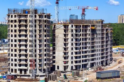 Large construction site including several cranes working on a building complex Stock Photos