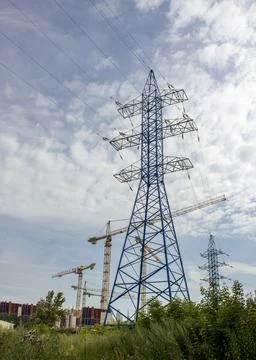 A large construction site, including several cranes, with a high-voltage mast in Stock Photos
