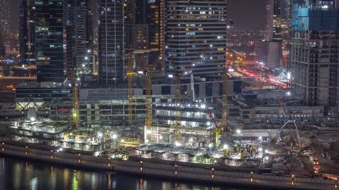 Large construction site with many working cranes night timelapse. Stockfoto's