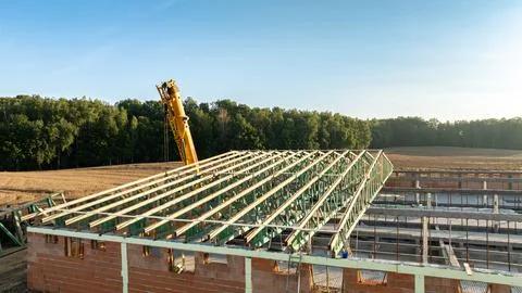 A large construction site with a partially built roof structure made of gre.. Stock Photos