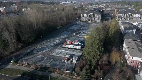 A Large Construction Site Sits Between Forested Areas and Apartment Buildings 스톡 동영상 331033490